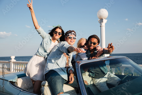 Happy young people driving car near the sea © Drobot Dean