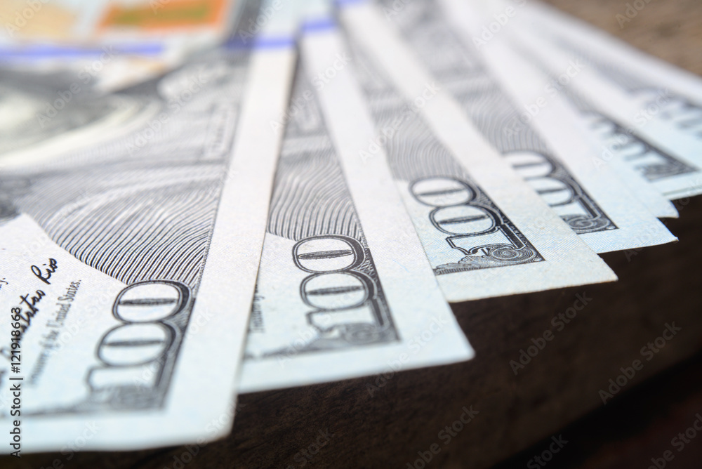 close-up of one hundred dollars on wooden table close-up of one hundred dollars on wooden table