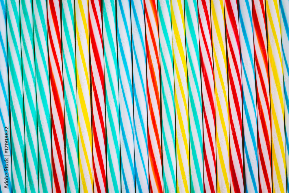 Striped drink straws in different colors background Striped drink straws in different colors background