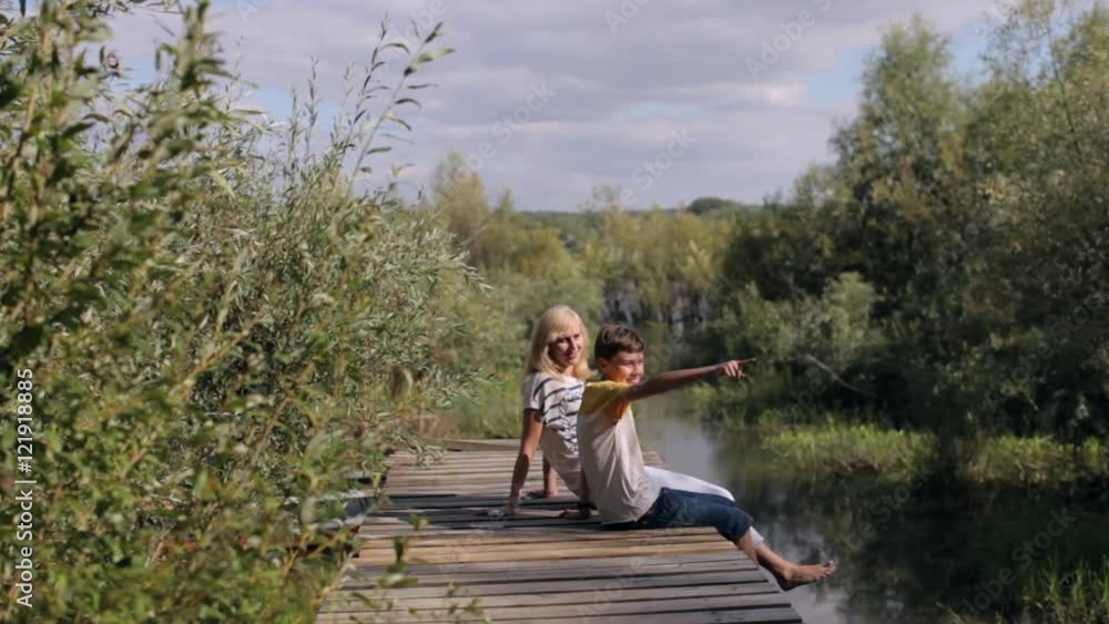 Mother and Son Sitting on a Wooden Pier Mother and Son Sitting on a Wooden Pier