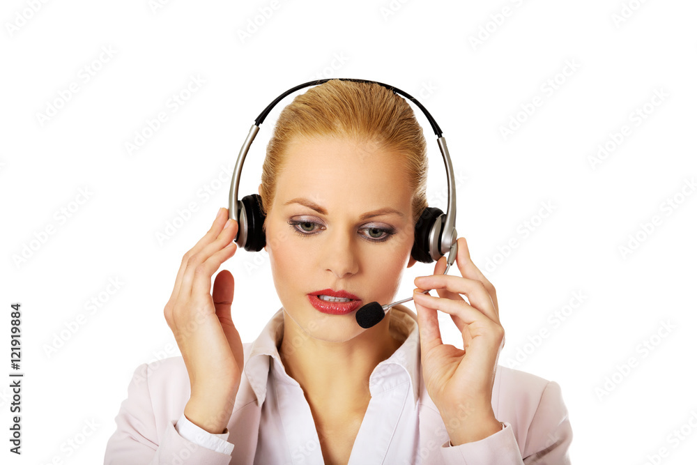 Young woman helpline operator is trying to hear something through headphones Young woman helpline operator is trying to hear something through headphones