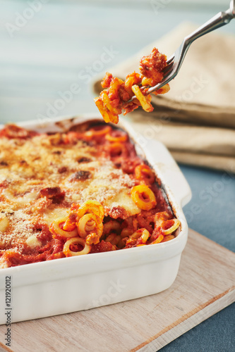 Baked anelletti pasta with mince, sauce and mozzarella. Typical sicilian dish