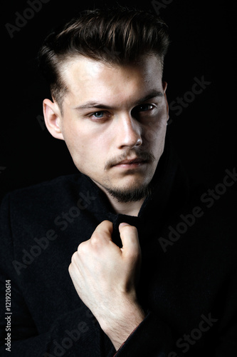 Studio Portrait of a Handsome Young Man in Black Suit