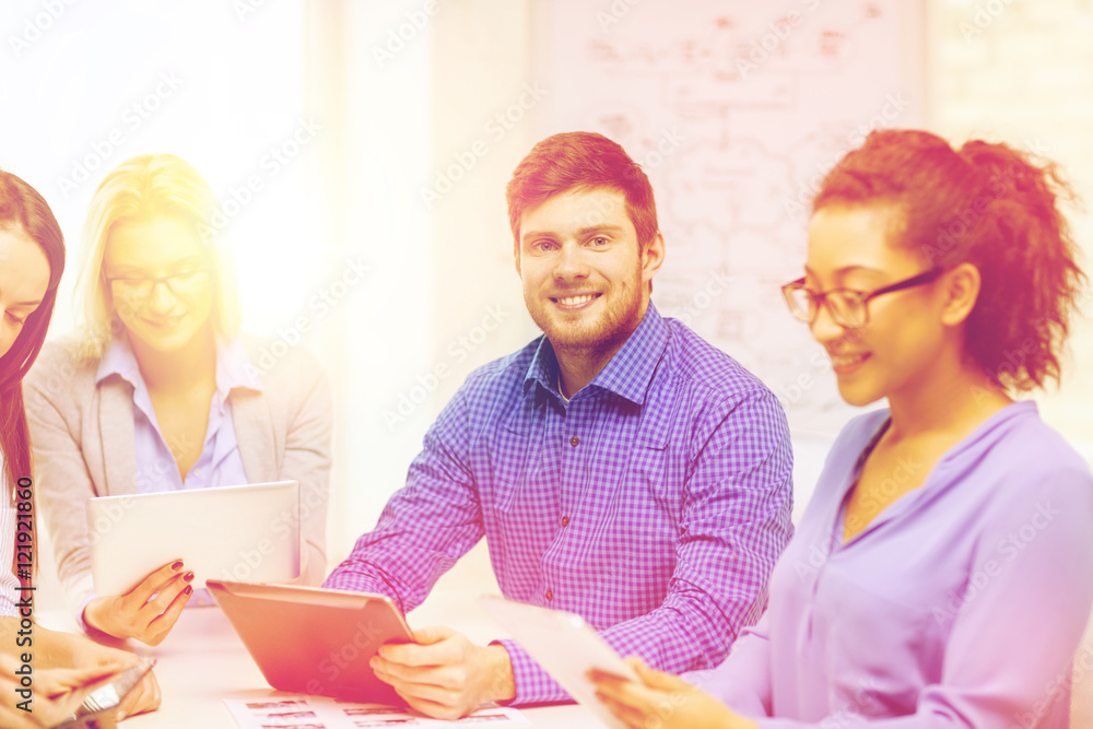 smiling team with table pc and papers working smiling team with table pc and papers working