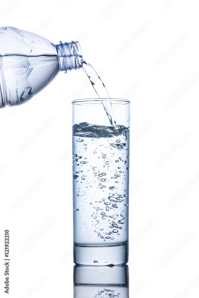 Drinking water is poured into a glass from bottle Drinking water is poured into a glass from bottle