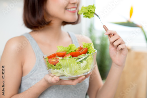 Beautiful young asian girl eating salad. smiling happy girl eati