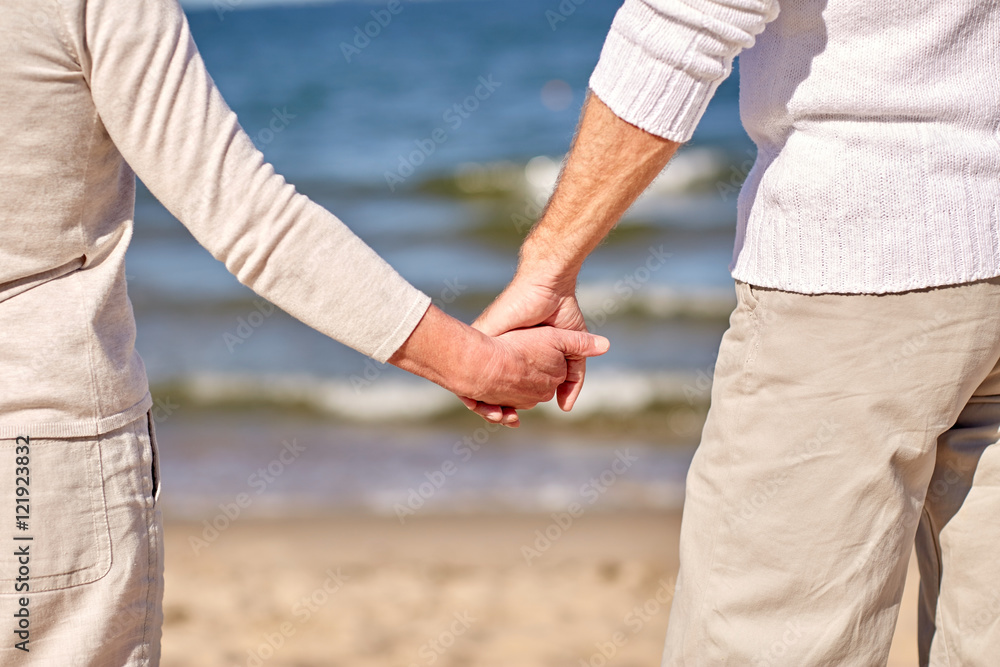 close up of senior couple holding hands on beach close up of senior couple holding hands on beach
