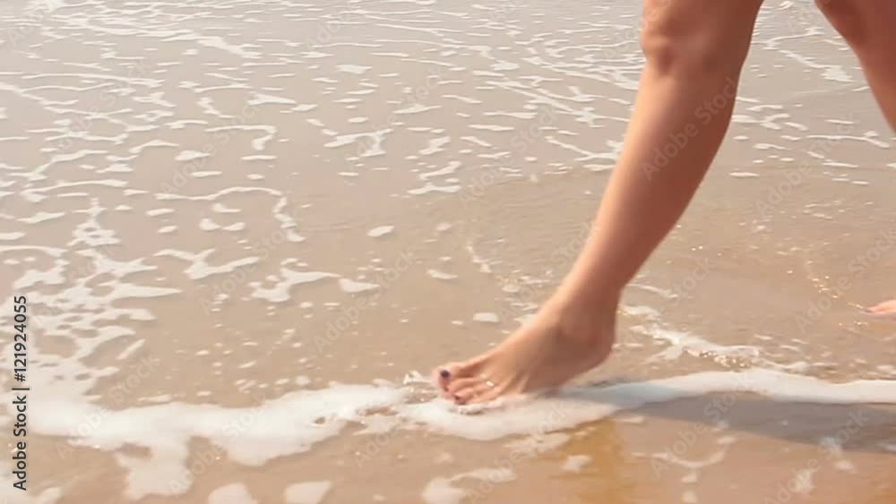 woman walking on sand beach leaving footprints woman walking on sand beach leaving footprints