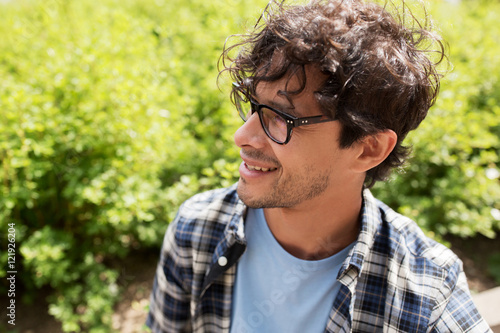 close up of smiling man in eyeglasses outdoors