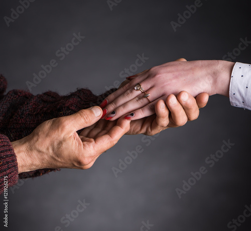 Old man holding young woman's hand