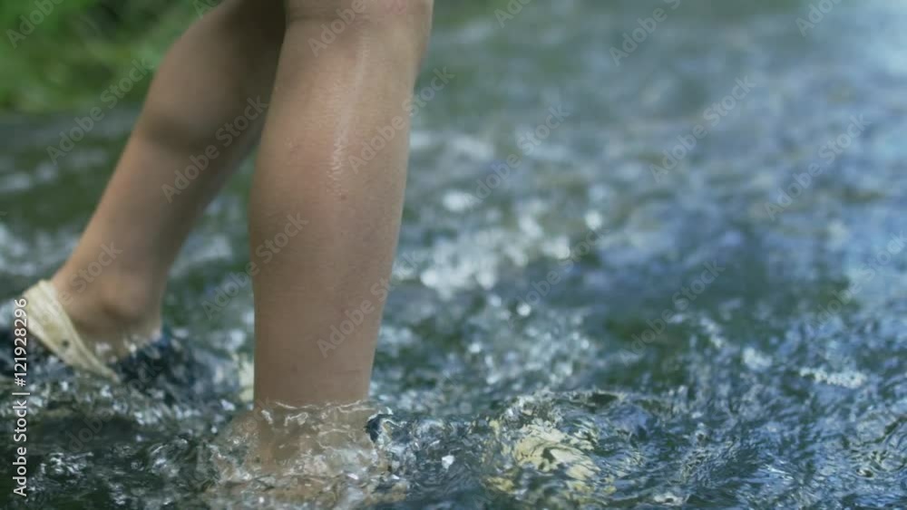 Slow motion handheld close-up of a boy wading shallow river rapids, shot on RED Epic Dragon R3D, 120fps Slow motion handheld close-up of a boy wading shallow river rapids, shot on RED Epic Dragon R3D, 120fps