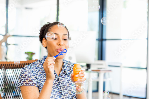 Portrait of smiling afro-american office worker blowing bubbles Free Download Portrait of smiling afro-american office worker blowing bubbles - GFXLoad