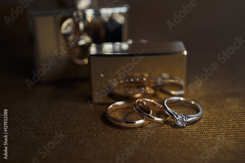 The wedding rings stand near perfume