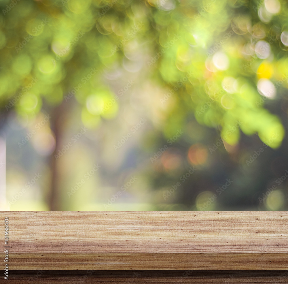 Empty wooden table over blurred tree with bokeh background Empty wooden table over blurred tree with bokeh background
