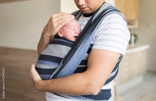 Tableau sur toile Unrecognizable young father with his son in sling