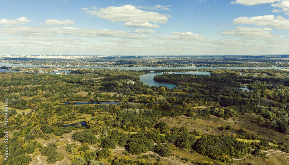 Panoramic view of the Kiev suburb from above. Aerial view. Outdoor. Beautiful photos of nature with fields river and reservoirs with high-rise buildings in the background.