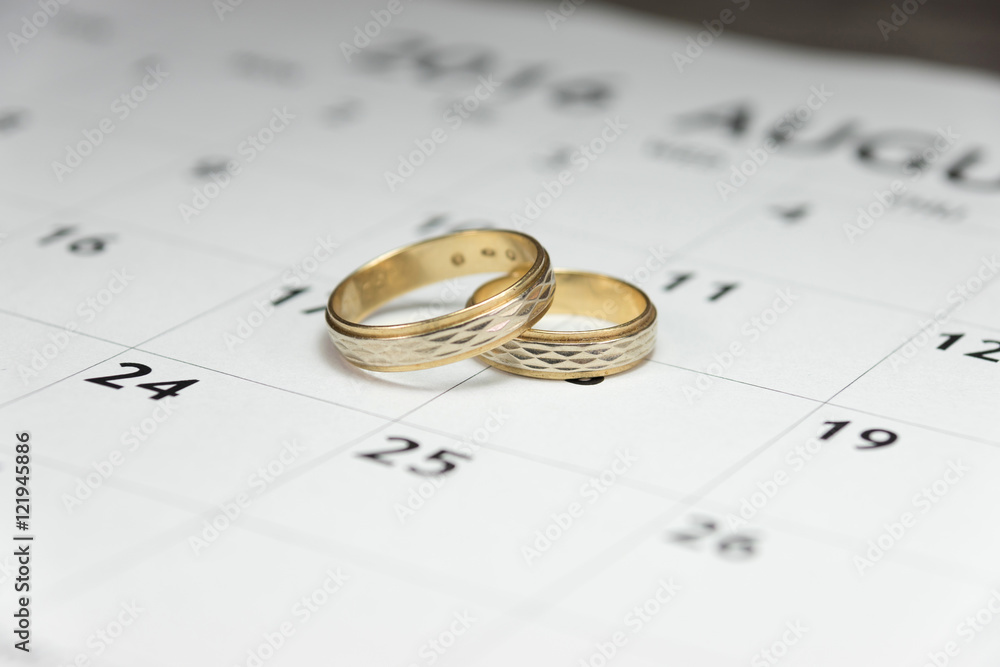 Ein Termin für die Hochzeit, Eheringe und ein Kalender Ein Termin für die Hochzeit, Eheringe und ein Kalender