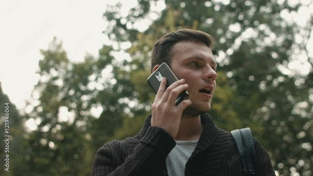 Handsome young business man talking on smartphone and walking away smiling happy wearing suit jacket outdoors. Handsome young business man talking on smartphone and walking away smiling happy wearing suit jacket outdoors.
