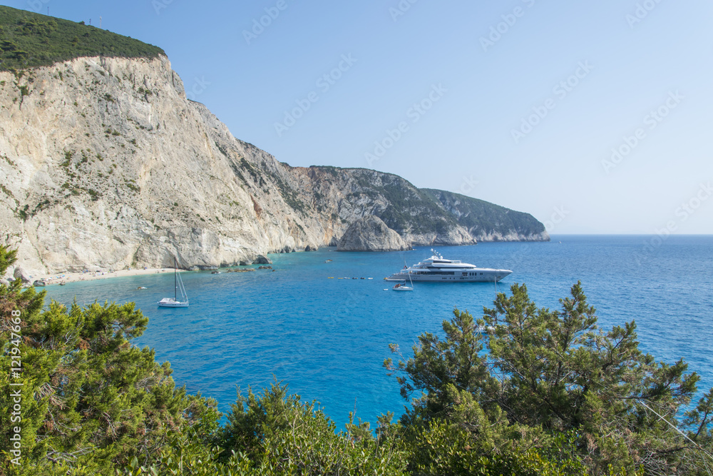 Lanscape of steep rocky cliff, beautiful blue green sea and yacht