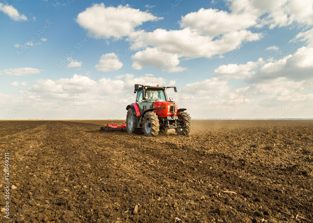 Farmer in tractor preparing land with seedbed cultivator