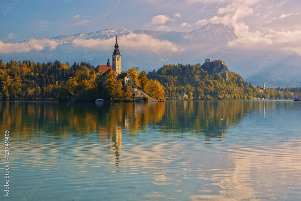 Bled lake and pilgrimage church with autumn mountain landscape background