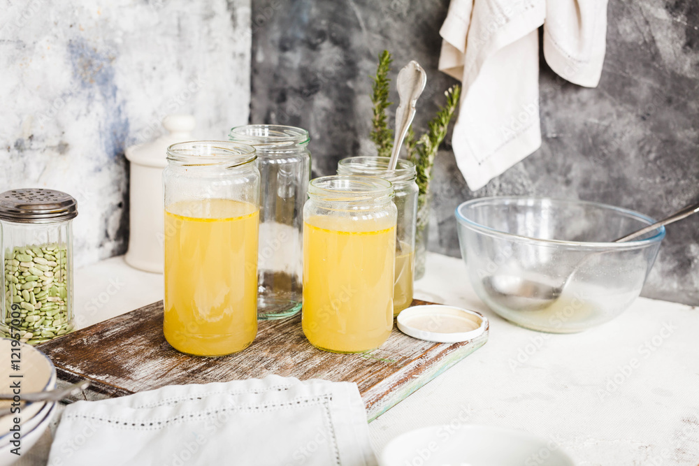 Bouillon glass jars over kitchen table. Preparation soup concept.