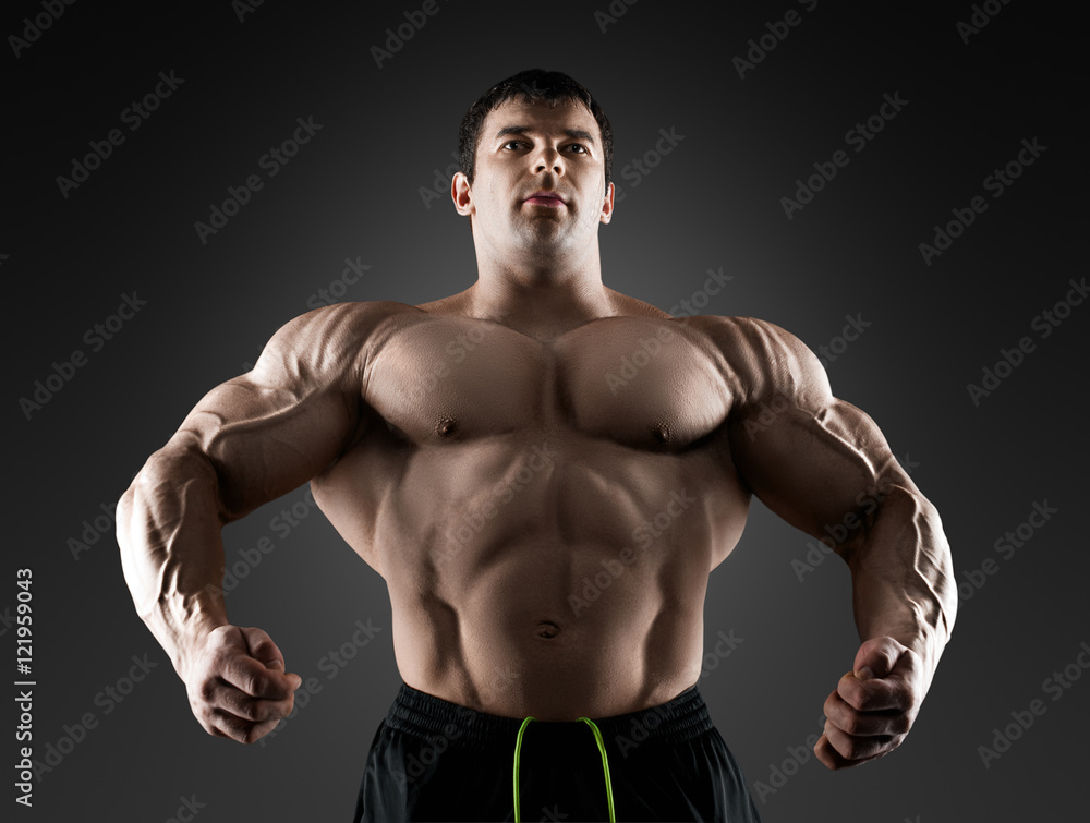 Handsome muscular bodybuilder posing over black background. Handsome muscular bodybuilder posing over black background.