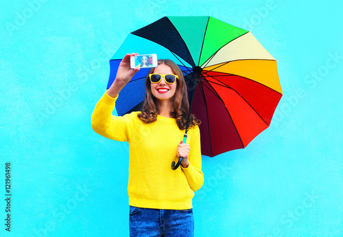 Fashion pretty smiling woman with colorful umbrella taking autum