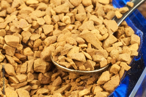 Coffee beans and instant coffee. Granules of instant coffee background. Instant coffee in a glass dish. Preparation of soluble coffee. Decorate store coffee.
