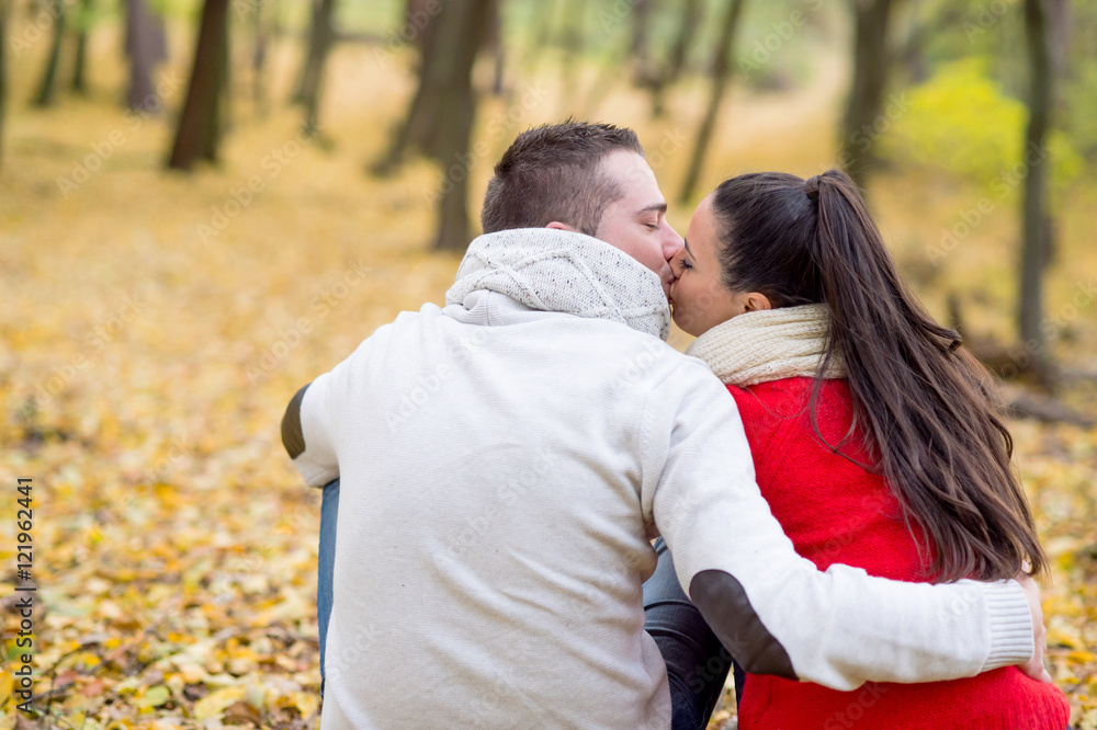 Beautiful couple in autumn park sitting on the ground Beautiful couple in autumn park sitting on the ground