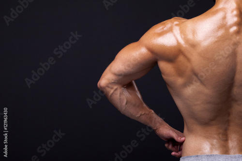 Photos Rear view of a male bodybuilder flexing his back