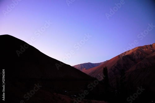 Sunset behind the black hills with a purple and blue sky in Pisco Elqui in Chile, South America
