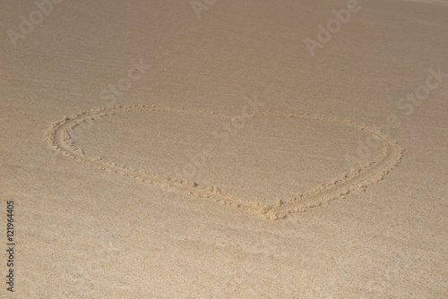 Beautiful heart shape drawn in the sand