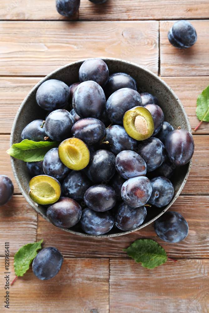 Tasty and ripe plums on brown wooden table Tasty and ripe plums on brown wooden table