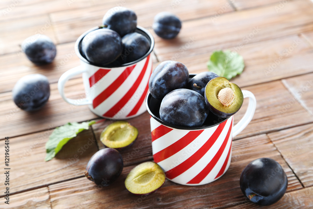 Tasty and ripe plums on brown wooden table Tasty and ripe plums on brown wooden table