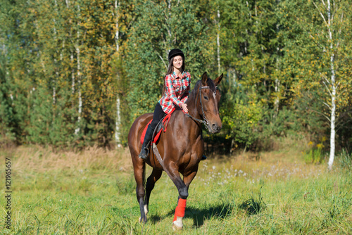 beautiful long hair young woman riding a horse outdoor