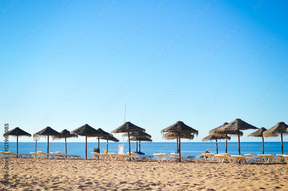 Fototapeta premium Beach ready for tourists. Golden sand with blue sky outdoors nature background