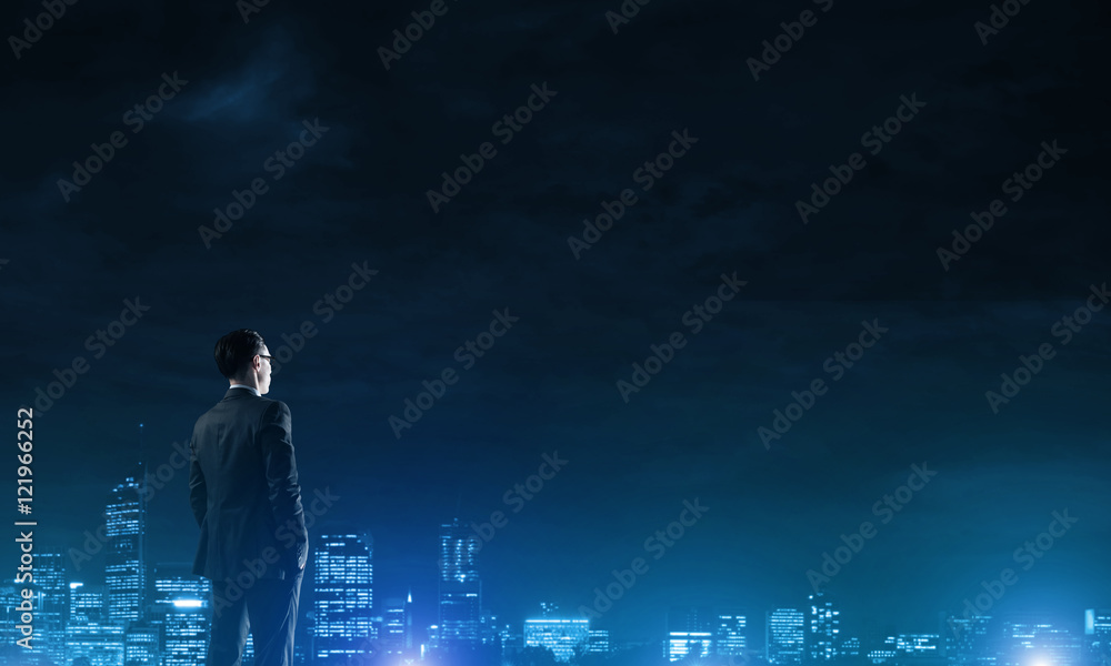 Businessman viewing night glowing city Businessman viewing night glowing city