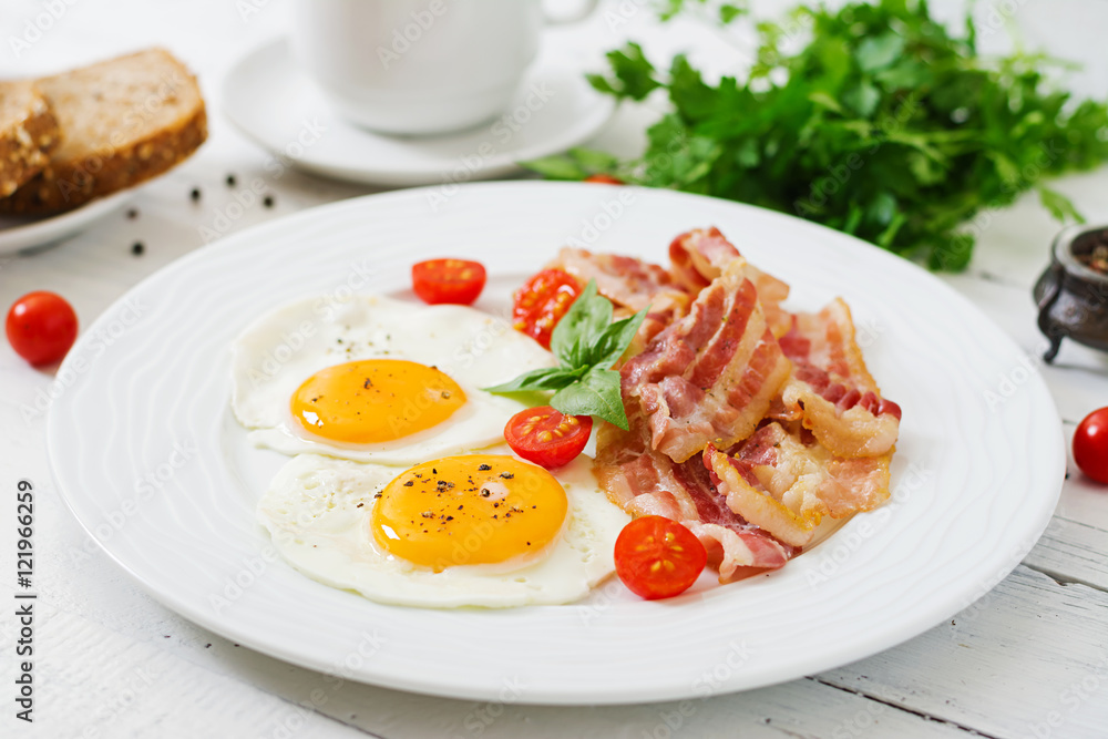 English breakfast - fried egg, tomatoes and bacon. English breakfast - fried egg, tomatoes and bacon.