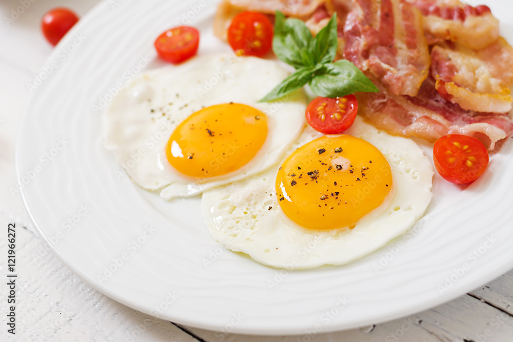English breakfast - fried egg, tomatoes and bacon. English breakfast - fried egg, tomatoes and bacon.