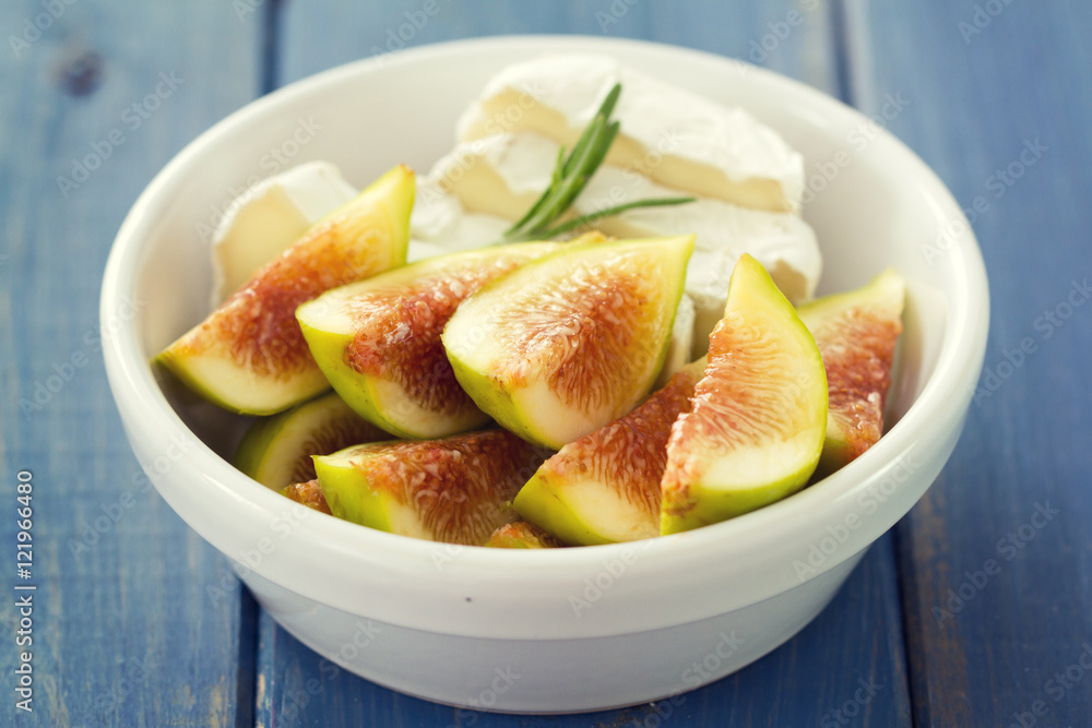 figs with cheese in white bowl on wooden background figs with cheese in white bowl on wooden background