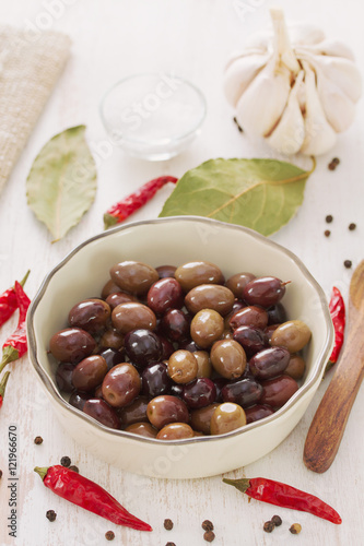 olives in bowl on white wooden background