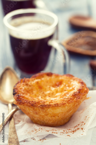 portuguese dessert pastel de nata with cup of coffee on blue wooden background