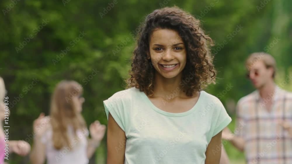 Young lady with white teeth, perfect skin smiling, dancing with friends at party Young lady with white teeth, perfect skin smiling, dancing with friends at party