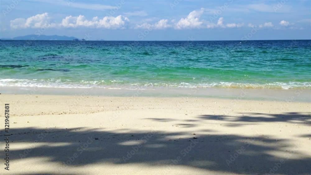 View of white sand, big rock, beach, tree shade, blue sky with clouds and harmony waves at Lalang Island, Lumut, Perak, Malaysia, facing to Straits of Malacca loop View of white sand, big rock, beach, tree shade, blue sky with clouds and harmony waves at Lalang Island, Lumut, Perak, Malaysia, facing to Straits of Malacca loop