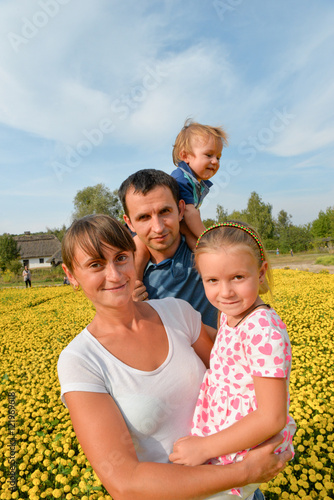 Lifestyle portrait of a happy young modern family.Mother,father,daughter and son spending time outdoor on a sunny day.Having fun on vacation.Concept of happy family life,love and happiness
