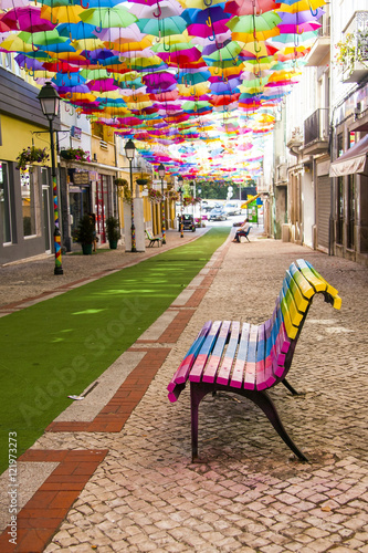 Street decorated with colored umbrellas and colorful bench .Agueda,Portugal