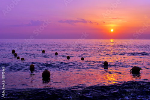 purple sunset and lineas of buoys on the sea