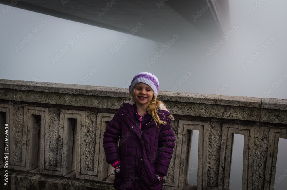 child by foggy bridge