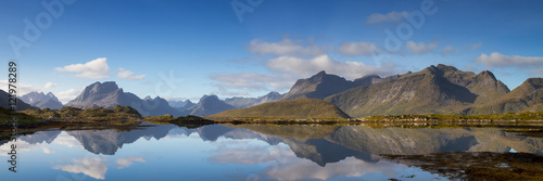 Panorama of a mountain range reflecting in a fjord